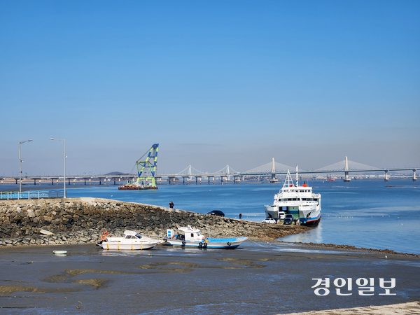 3일 오전 인천 중구 영종도 구읍뱃터에 도착한 배 뒤로 청라하늘대교가 보인다. 2026.02.03 /유진주기자 yoopearl@kyeongin.com