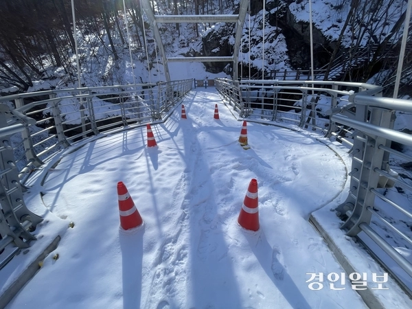 가평 명지산군립공원 등산로 입구에서 1.2㎞ 떨어진 곳에 조성된 아치교 ‘구름다리’에 눈이 쌓여 있는 가운데 다리 중간 부근에 라바콘이 설치돼 있다. 가평/김민수기자 kms@kyeongin.com