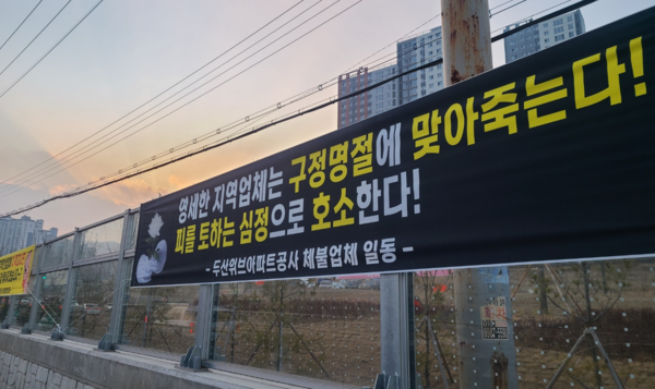 12일 설날이 며칠 남지 않은 가운데 공사대금을 받지 못해 어려움을 호소하는 현수막이 광주의 한 아파트 주변에 걸려있다. 광주/이윤희기자·flyhigh@kyeongin.com