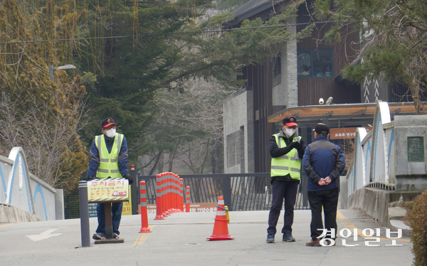 지난 11일 오전 서울대 안양수목원을 찾은 한 방문객이 정문에서 예약 확인을 하고 있는 수목원 관계자에게 사전예약제 시행 관련 설명을 듣고 있다. 예약 없이 찾아온 이 방문객은 결국 발길을 돌렸다. 2026.3.11 안양/박상일기자 metro@kyeongin.com