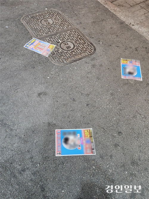 지난 14일 밤 수원시 팔달구 인계동 수원시청 뒤 ‘인계박스’ 길거리에 광고물이 뿌려져 있다. 2026.3.14 /김형욱기자 uk@kyeongin.com