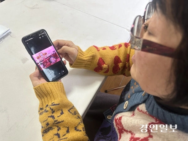 강태완(32·몽골)씨의 엄마 이은혜(몽골명 엥흐자르갈)씨가 장례식장 사진을 보여주고 있다. 강씨는 거주비자를 얻기 위해 전북 김제의 한 특장차 제조업체에서 일하다 지난해 산업재해로 숨졌다. /목은수기자 wood@kyeongin.com