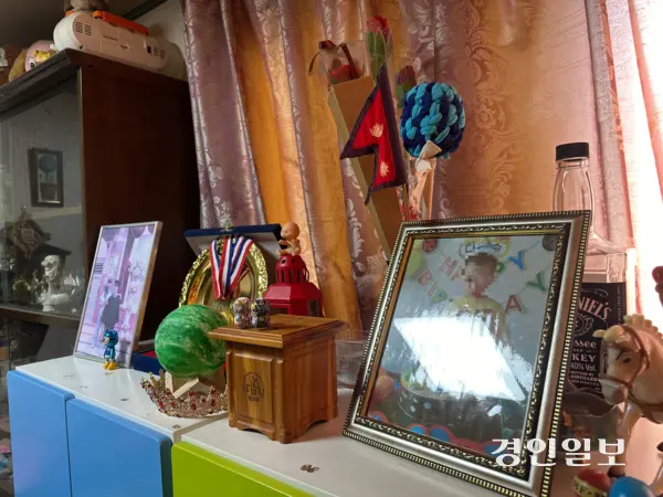 미샤(29·네팔)씨의 아들 우진의 어릴적 사진이 네팔 국기와 함께 진열되어 있다. 2025.8.30 /목은수기자 wood@kyeongin.com
