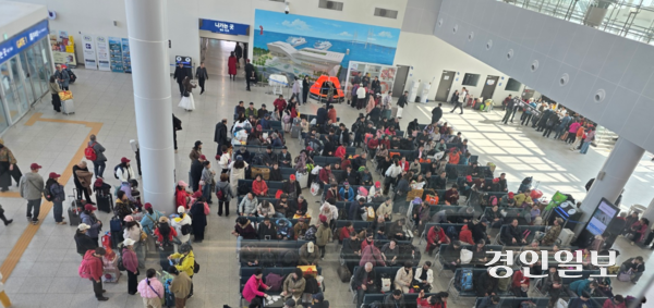 출국을 앞둔 평택항 국제여객터미널 대합실 내 여행객들이 수속을 기다리고 있다. 이들은 셔틀버스를 타기 위해 무거운 수화물을 들고 긴 줄을 서야하는 등 불편을 겪고 있다. 2026.3.29 평택/김종호기자 kikjh@kyeongin.com