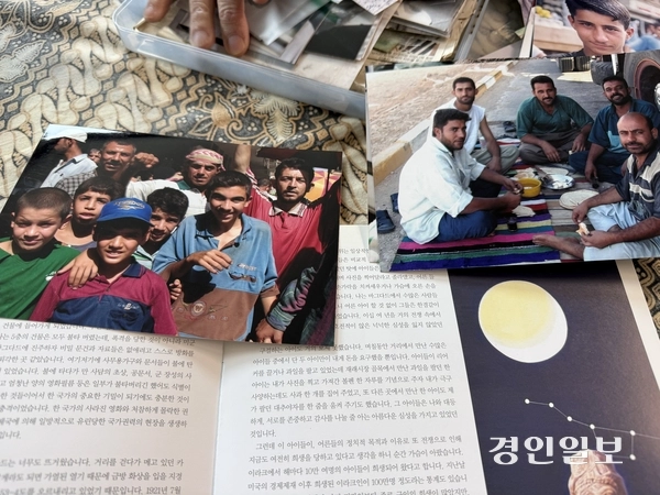 이종구 작가가 2003년 여름 이라크 바그다드에서 만난 사람들을 촬영한 사진과 각종 자료를 꺼내 보이고 있다. 2026.3.27 /박경호기자 pkhh@kyeongin.com