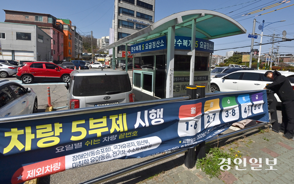 7일 인천시 남동구 공영주차장에서 관계자들이 승용차 5부제 시행을 알리는 현수막을 부착하고 있다. 2026.4.7 /김용국기자 yong@kyeongin.com