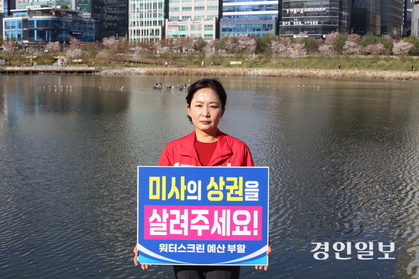 하남시의원 선거(미사 1·2동)에도전하는 이정연(국) 예비후보가 13일 오후 미사호수공원에서 ‘미사의 상권을 살려달라’는 1인 시위를 진행하고 있다. 이 예비후보 딋쪽엔 잦은 고장으로 흉물이 된 음악분수가 보이고 있다. 2026.4.13 하남/문성호기자 moon23@kyeongin.com