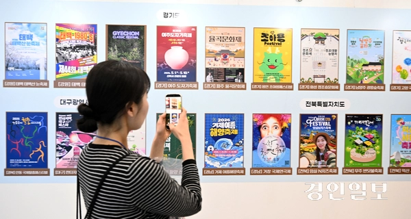 한 시민이 지역별 축제 홍보 포스터를 촬영하고 있다. 2026.4.17 /임열수기자 pplys@kyeongin.com