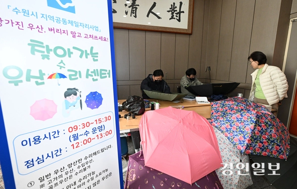 21일 수원시 권선구 세류2동 행정복지센터에서 열린 ‘찾아가는 우산 수리센터’에서 관계자들이 우산을 고치고 있다. 2026.4.21 /최은성기자 ces7198@kyeongin.com
