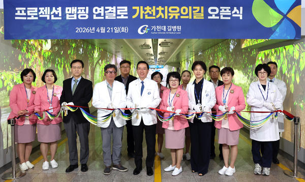 가천대 길병원 본관 지하 연결로에 조성된 ‘가천 치유의 길’ 입구에서 21일 김우경 가천대 길병원장 등 병원 주요 보직자들이 기념 촬영을 하고 있다. /가천대 길병원 제공