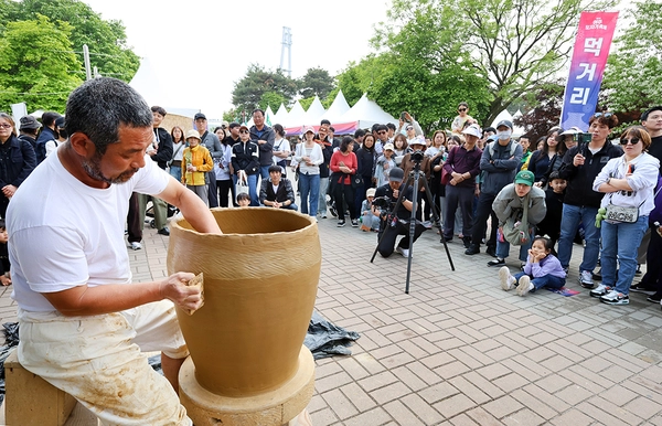 지난해 여주도자기축제에서 도예 명장이 대형 옹기 제작 퍼포먼스를 선보이자, 관람객들이 발걸음을 멈추고 흙이 그릇으로 빚어지는 과정을 지켜보고 있다. /여주시 제공
