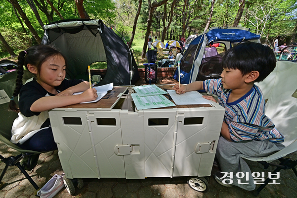 어린 참가자들이 수레를 책상 삼아 원고지에 글을 쓰고 있다. 2026.4.25 /조재현기자 jhc@kyeongin.com