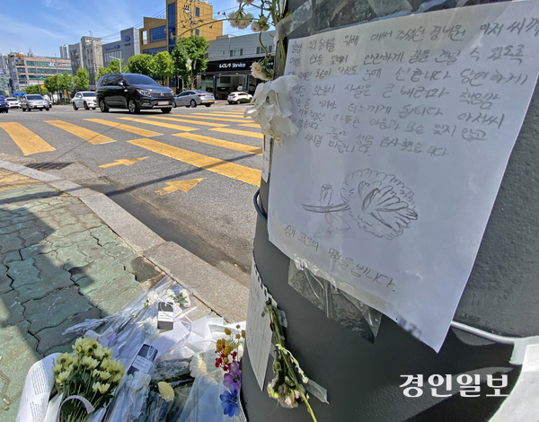 최근 학생들의 등굣길 통행을 돕던 아파트 경비원이 차량에 치여 숨진 사고가 발생한 가운데 29일 오후 인천시 미추홀구 아파트 인근 횡단보도에 경비원을 추모하는 메시지와 조화가 놓여있다. 2026.4.29 /조재현기자 jhc@kyeongin.com
