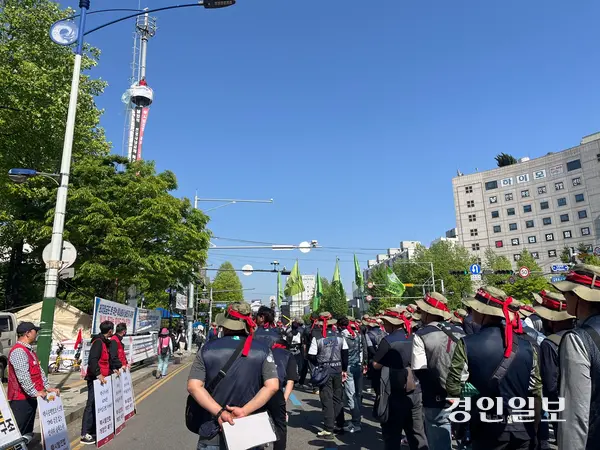노동절인 1일 오후 2시께 인천 남동구 예술회관역 일대에서 열린 ‘2026 세계노동절 인천대회’에서 참가자들이 20m 상공 통신탑에서 고공농성 중인 택시노동자 고영기씨와 인사를 나누고 있다. 2026.5.1 /송윤지기자 ssong@kyeongin.com