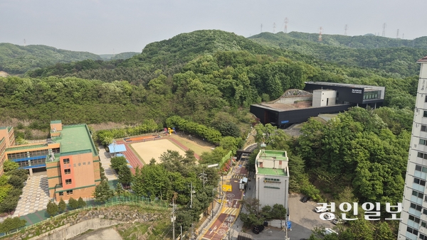 인근 아파트 옥상에서 내려다본 용인 지곡초등학교. 오른쪽 위에 실크로드시앤티의 ‘콘크리트혼화제연구소’가 보인다.  학생들과 인근 주민들은 학교 담벼락을 두고 들어선 연구소에서 폐기물이 어떻게 처리되는지 정확히 알지 못한 채 불안한 생활을 하고 있다. 용인/오수진기자 nuri@kyeongin.com