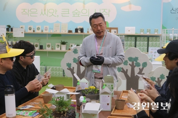 2026 고양국제꽃박람회에서 산불피해지역 복구 캠페인 부스를 운영하는 (주)틔움세상 유계림 이사가 시드볼 만들기 체험에 참여한 관람객들에게 시드볼에 대해 설명하고 있다. 고양/김도란기자 doran@kyeongin.com