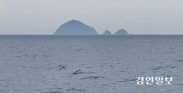 말도 앞바다에서 바라본 함박도. 함박도 산 꼭대기에 군 경계 시설물과 송수신 안테나로 보이는 시설물이 눈에 띈다. 2026.5.11 /정진오기자 schild@kyeongin.com