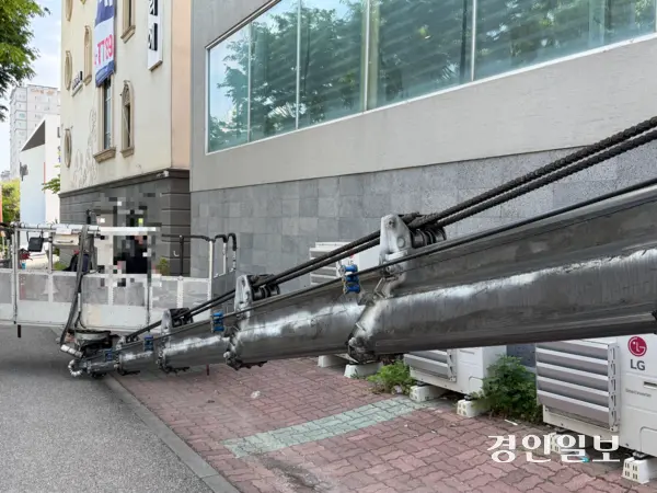 집단 식중독 신고가 들어온 매장 앞에서 철거 업체 직원들이 건물 외벽에 붙은 간판을 떼고 있다. 2026.05.13 /마주영기자 mango@kyeongin.com