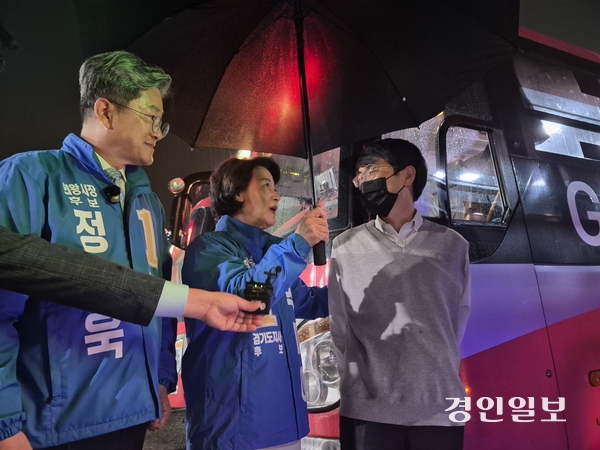 21일 추미애 더불어민주당 경기도지사 후보가 의왕 월암공영차고지에서 운행을 마치고 돌아오는 3900번 버스 기사의 퇴근길을 마중 나와 우산을 씌워주고 있다. 2026.2.21 /김태강 기자 think@kyeongin.com