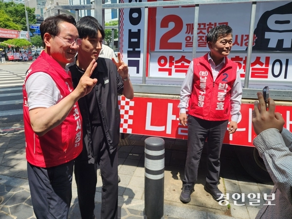 국민의힘 유정복 인천시장 후보가 24일 구월동 롯데백화점 앞 사거리에서 선거 유세를 하며 시민과 기념 촬영을 하고 있다. 2026.5.24 /한달수기자 dal@kyeongin.com