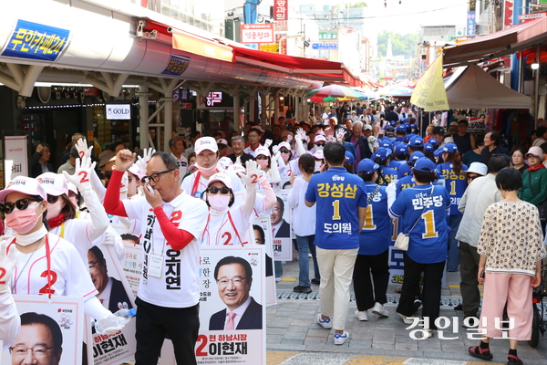 24일 오후 4시께 장날을 맞은 덕풍전통시장 입구에서 집중유세를 마친 더불어민주당 선거운동원과 합동연설회를 시작하려는 국민의힘 선거운동원이 마주치자 서로 지지후보 이름을 연호하는 등 팽팽한 신경전이 펼쳐졌다. 2026.5.24 하남/문성호기자 moon23@kyeongin.com