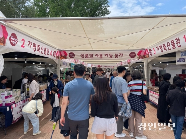 지난 23일 개막한 가평군 자라섬 꽃 페스타를 찾은 방문객들이 농특산물 판매장을 둘러보고 있다. 축제가 열리는 남도 약 11만㎡ 규모 정원에는 양귀비, 아이슬란드 포피, 델피니움, 로벨리아, 콜레우스, 맨드라미 등 다양한 봄꽃과 초화류 등이 조성됐다. 2026.05.25 가평/김민수기자 kms@kyeongin.com