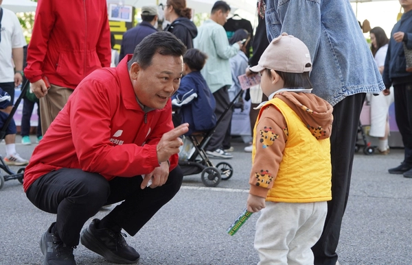 국민의힘 김석훈 안산시갑 국회의원 재보선 후보가 안산국제거리극축제 현장에서 만난 어린이와 눈높이를 맞춰 대화하고 있다. /김석훈 후보 캠프 제공
