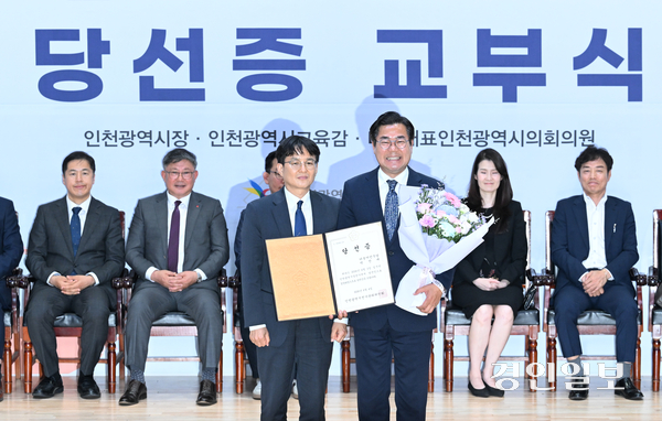 더불어민주당 박찬대 인천시장 당선자(오른쪽)가 4일 인천 미추홀구 인천시선거관리위원회에서 열린 ‘제9회 전국동시지방선거 당선증 교부식’에서 당선증을 받고 있다. 2026.6.4 /조재현기자 jhc@kyeongin.com