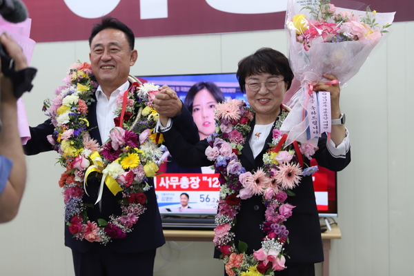 이충우 여주시장 당선자와 강정옥 여사가 4일 새벽 선거사무소에서 꽃목걸이를 걸고 지지자와 손을 맞잡으며 당선의 기쁨을 나누고 있다. 2026.6.4 /이충우 후보 캠프 제공
