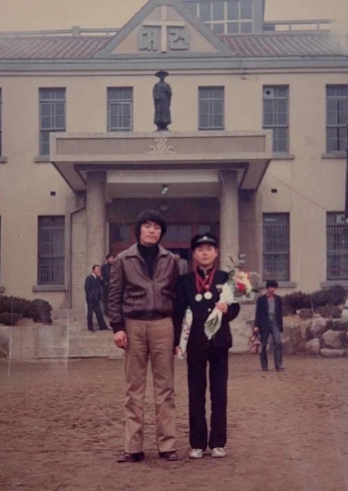 학교 운동장에서 미술 선생님과 사진을 찍고 있는 중학생 박찬대. /박찬대 당선자 측 제공