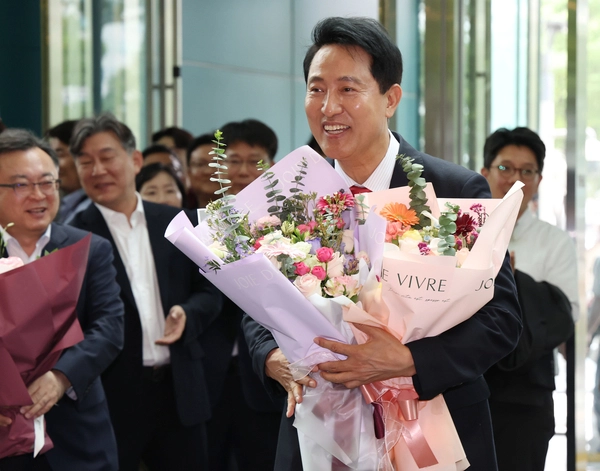 오세훈 서울시장이 4일 서울시청 로비에서 꽃다발을 받은 뒤 기뻐하고 있다. 2026.6.4 /공동 취재