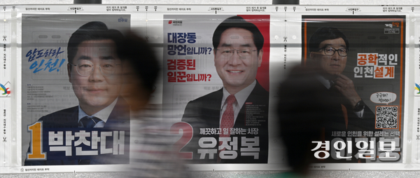 인천시 검단신도시에 설치된 6·3 지방선거 인천시장 후보자 선거벽보 사이로 시민들이 발길을 옮기고 있다. 2026.5.26 /조재현기자 jhc@kyeongin.com