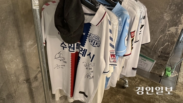 정지영커피로스터즈 행궁본점 지하 1층에 수원FC 유니폼들이 걸려있다. 2026.6.12 / 윤혜경기자 hyegyung@kyeongin.com