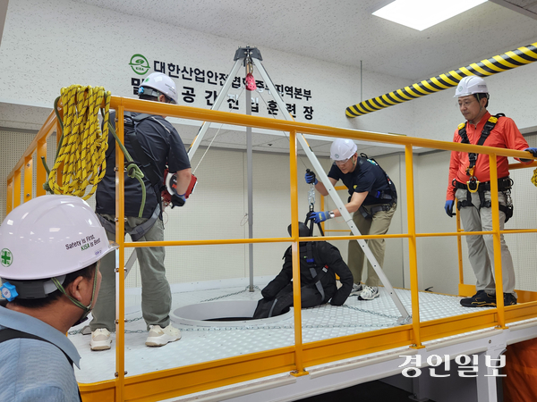 지난 19일 오전 인천 부평구 대한산업안전협회 중부지역본부 교육장에 마련된 밀폐공간 산업훈련장에서 교육생들이 맨홀 구조용 삼각대를 이용해 구조 작업 실습을 하고 있다. 2026.6.19 /유진주기자 yoopearl@kyeongin.com