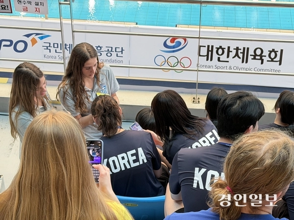 23일 인천문학박태환수영장에서 열린 제24회 CMAS 세계핀수영대회 개막식에서 한국 선수들과 연락처를 주고 받고 있는 그리스 선수들. 2026.6.23/백효은기자100@kyeongin.com