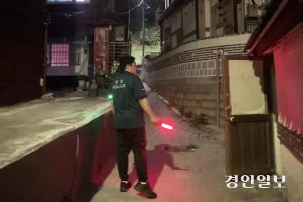 수원시 팔달구 남수동 골목에서 경찰관이 주변을 살피고 있다. 가로등이 없어 어두운 골목 안쪽까지 직접 들어가 취약 지점을 확인했다. 2026.6.25 /유혜연기자 pi@kyeongin.com
