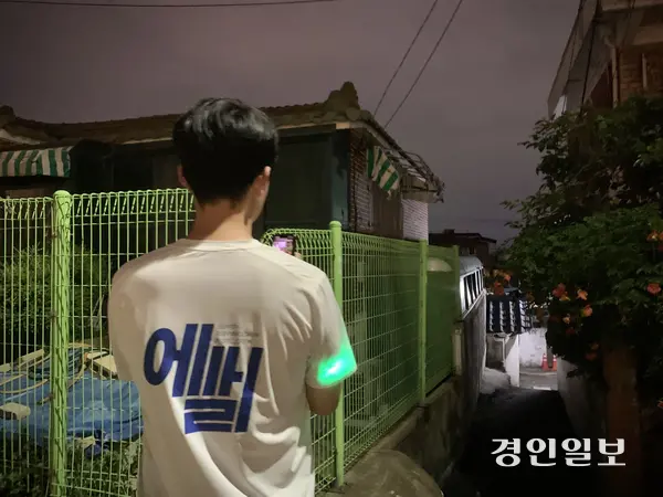 지난 25일 한 참가자가 달리다 멈춰 서서 휴대전화로 골목 내 위험 지점을 촬영하고 있다. 이날 참가자들은 현장에서 확인한 취약 지점을 사진으로 기록해 수원팔달경찰서 범죄예방계에 전달했다. 2026.6.25 /유혜연기자 pi@kyeongin.com
