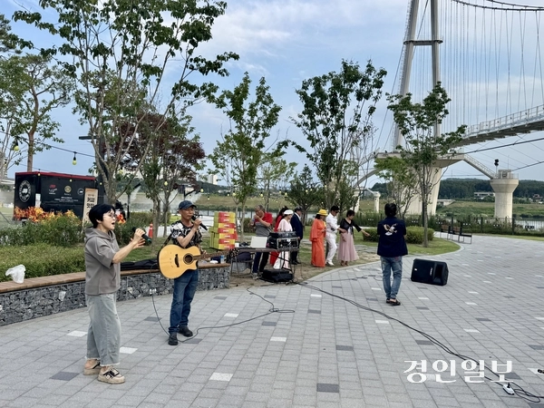 지난 3일 여주 남한강 출렁다리 아래 광장에서 지역 예술인들이 시민과 관광객 앞에서 버스킹 공연을 펼치고 있다. 2026.7.3 여주/양동민기자 coa007@kyeongin.com