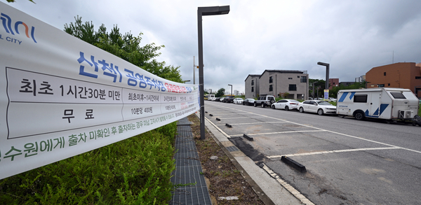 본격적인 여름 휴가철을 앞둔 가운데 6일 화성시의 한 공영주차장 앞에 캠핑카와 승용차가 불법 주정차 돼 있다. 2026.7.6 /최은성기자 ces7198@kyeongin.com