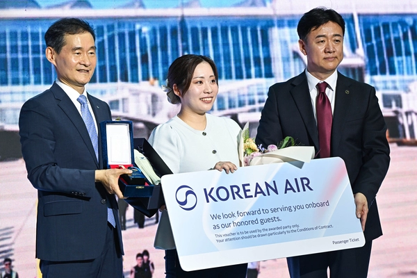 인천공항이 누적 여객 10억명을 달성한 7일 인천국제공항 제2여객터미널에서 김범호(왼쪽) 인천국제공항공사 사장직무대행과 송기원(오른쪽) 대한항공 인천공항지점장이 10억 번째 여행객인 하라 아야카(일본)에게 기념품과 항공권을 전달하고 있다. 2026.7.7 /조재현기자 jhc@kyeongin.com
