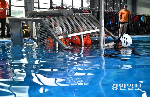 8일 용인시 처인구 경기도119특수대응단 수난구조훈련장에서 열린 소방항공대원 해상생환 훈련에서 특수구조팀 대원들이 수중 헬기 탈출 훈련을 하고 있다. 2026.7.8 /최은성기자 ces7198@kyeongin.com