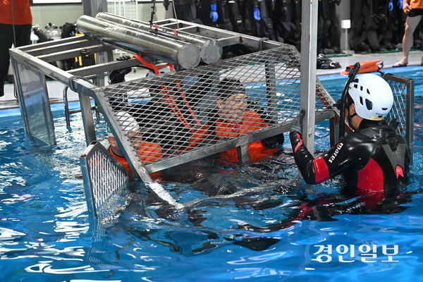 8일 용인시 처인구 경기도119특수대응단 수난구조훈련장에서 열린 소방항공대원 해상생환 훈련에서 특수구조팀 대원들이 수중 헬기 탈출 훈련을 하고 있다. 2026.7.8 /최은성기자 ces7198@kyeongin.com