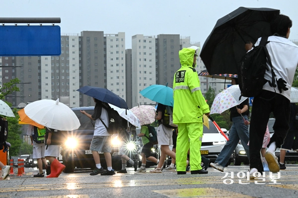 장맛비가 내린 8일 수원시내 한 횡단보도에서 우산을 쓴 학생들이 등교를 하고 있다. 2026.7.8 /최은성기자 ces7198@kyeongin.com