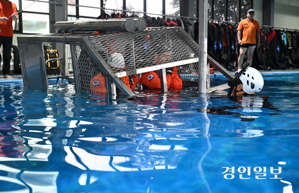 8일 용인시 처인구 경기도119특수대응단 수난구조훈련장에서 열린 소방항공대원 해상생환 훈련에서 특수구조팀 대원들이 수중 헬기 탈출 훈련을 하고 있다. 2026.7.8 /최은성기자 ces7198@kyeongin.com