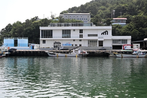 어선들이 정박해 있는 남해군 미조항 앞에 자리 잡은 옛 냉동창고 건물을 리모델링한 복합문화공간 스페이스 미조. /경남신문=성승건 기자