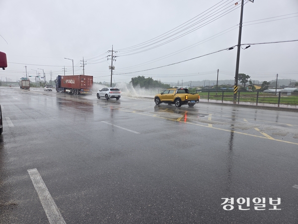 지난 8일 집중호우로 백사면 모전리 인근 도로에 빗물이 고이면서 차량들이 물보라를 일으키며 운행하고 있다. 이천/서인범기자 sib@kyeongin.com