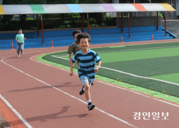 지난 14일 오전 고양 능곡초등학교 운동장에서 이제 막 등교한 학생이 밝은 표정으로 운동장 트랙을 뛰고 있다. 2026.7.14 고양/김도란 기자 doran@kyeongin.com