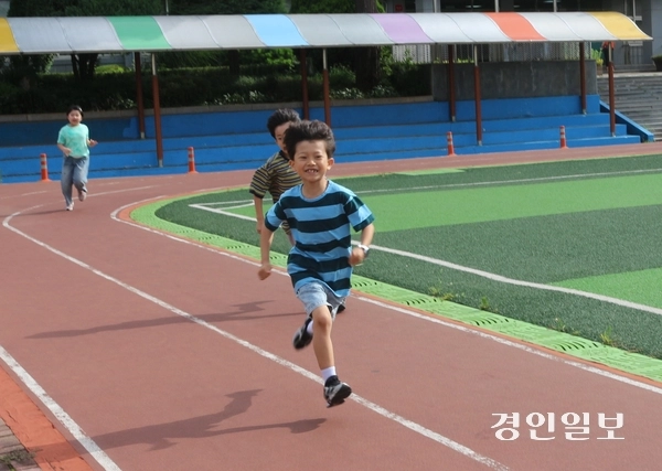 지난 14일 오전 고양 능곡초등학교 운동장에서 이제 막 등교한 학생이 밝은 표정으로 운동장 트랙을 뛰고 있다. 2026.7.14 고양/김도란기자 doran@kyeongin.com