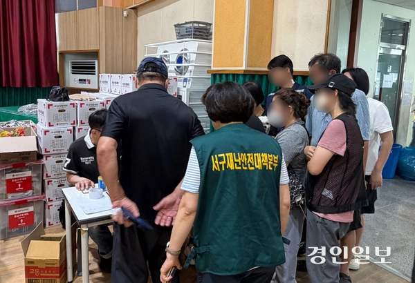 쿠팡물류센터 화재를 피해 신현초 대피소를 찾은 주민들이 대피소 관계자에게 인적사항을 말하고 있다. 2026.7.19 /조경욱기자 imjay@kyeongin.com