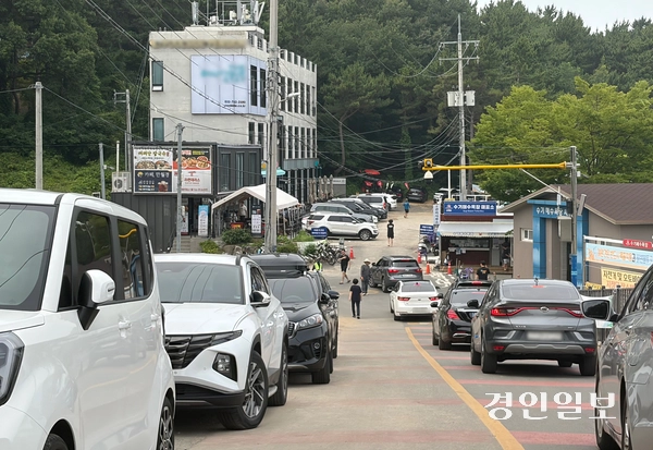 17일 인천 영종구 시도 수기해수욕장 진입로를 따라 불법주차 차량(왼쪽)이 줄지어 있다. 해수욕장에 진입한 차량들이 주차공간이 없어 되돌아 나가면서 교통 혼잡이 발생했다. 2026.7.17 /조경욱기자imjay@kyeongin.com